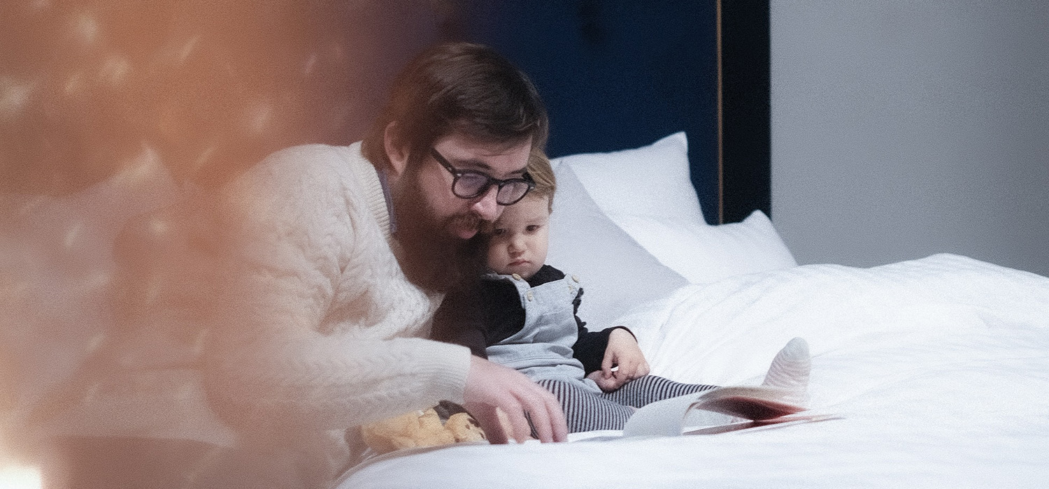 Homme qui lit une histoire à son bébé dans son lit