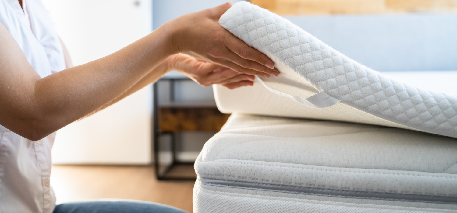 Installation d&rsquo;un surmatelas sur un matelas pour am&eacute;liorer le confort et soulager le mal de dos.