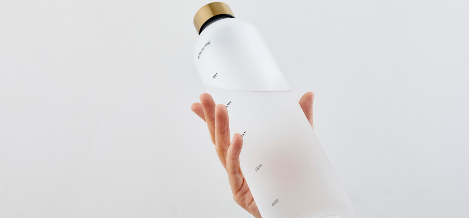 Personne tenant une gourde d'eau, un geste essentiel pour bien s'hydrater