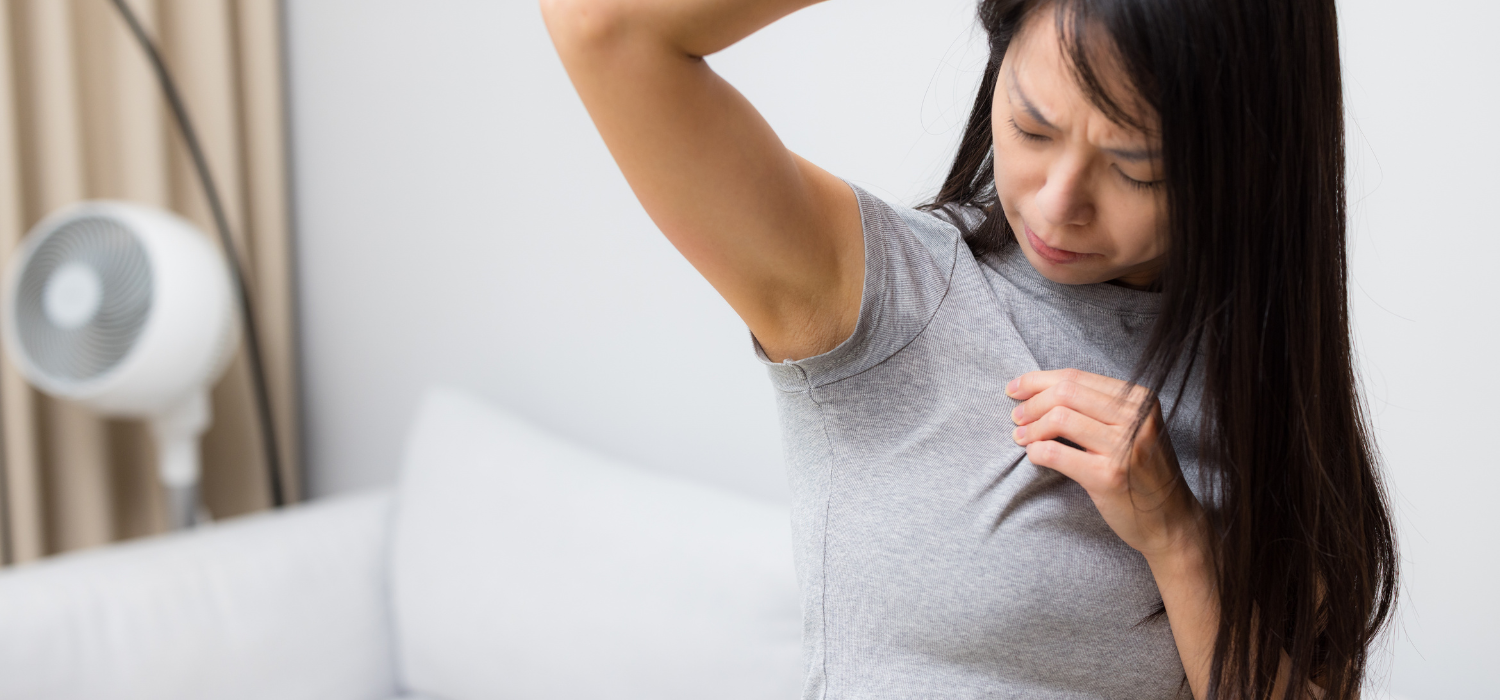 Femme constatant une trace de transpiration sous son vêtement