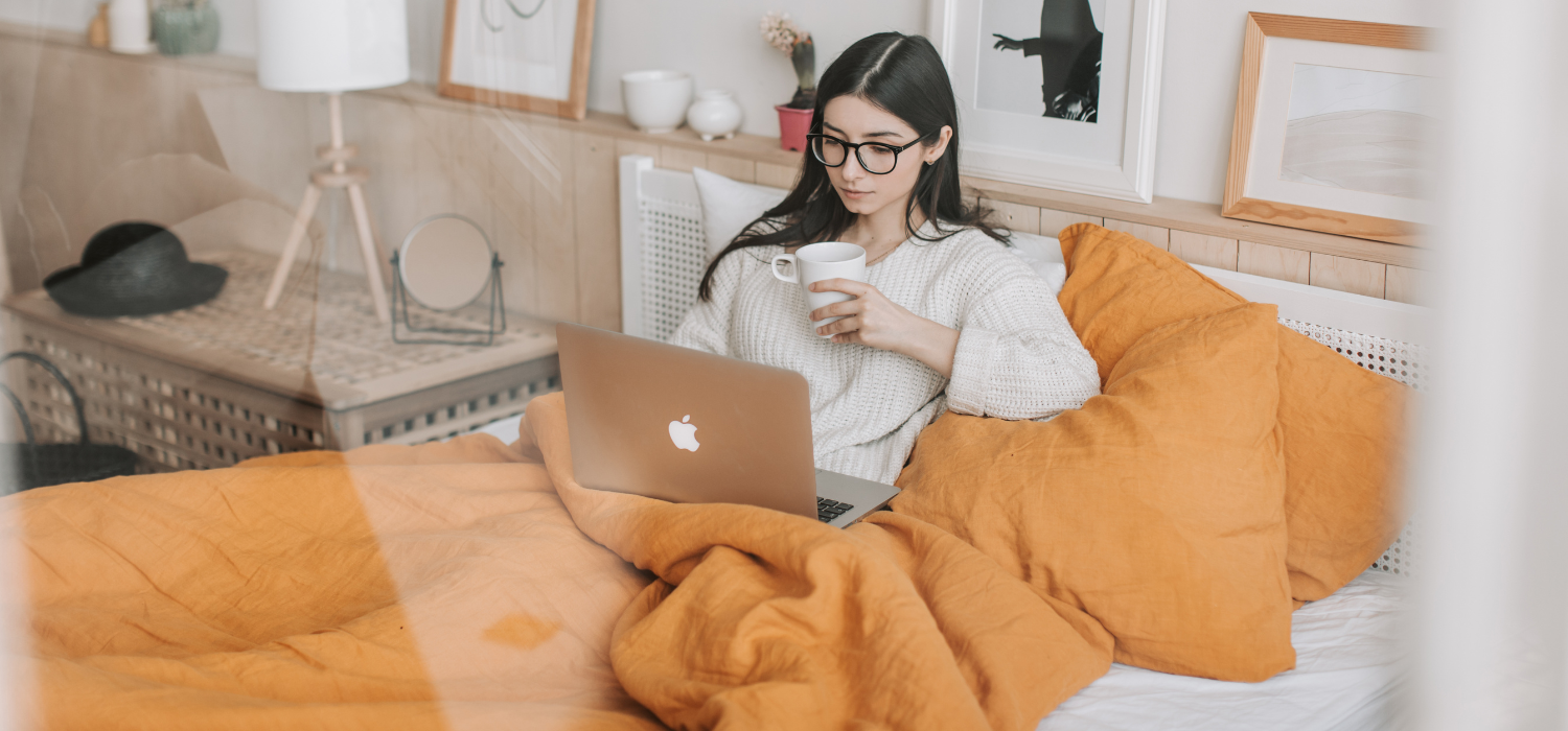 Étudiante travaillant sur son ordinateur portable dans son lit