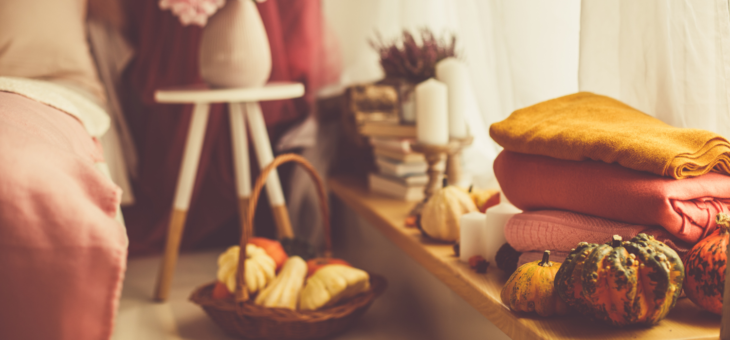 Chambre d&eacute;cor&eacute;e pour l&rsquo;automne avec des plaids, des couleurs chaleureuses et des citrouilles.